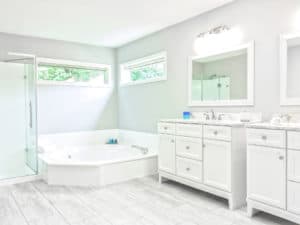 This image features a white bathroom and roung jet tub.