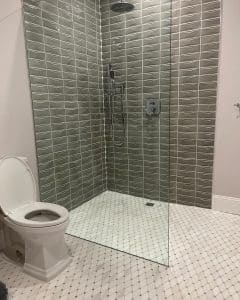 This image features a walk-in shower with grey tiling. 