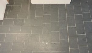 Bathroom floor with dark gray rectangular tiles arranged in a brick pattern, providing a sleek and contemporary look.